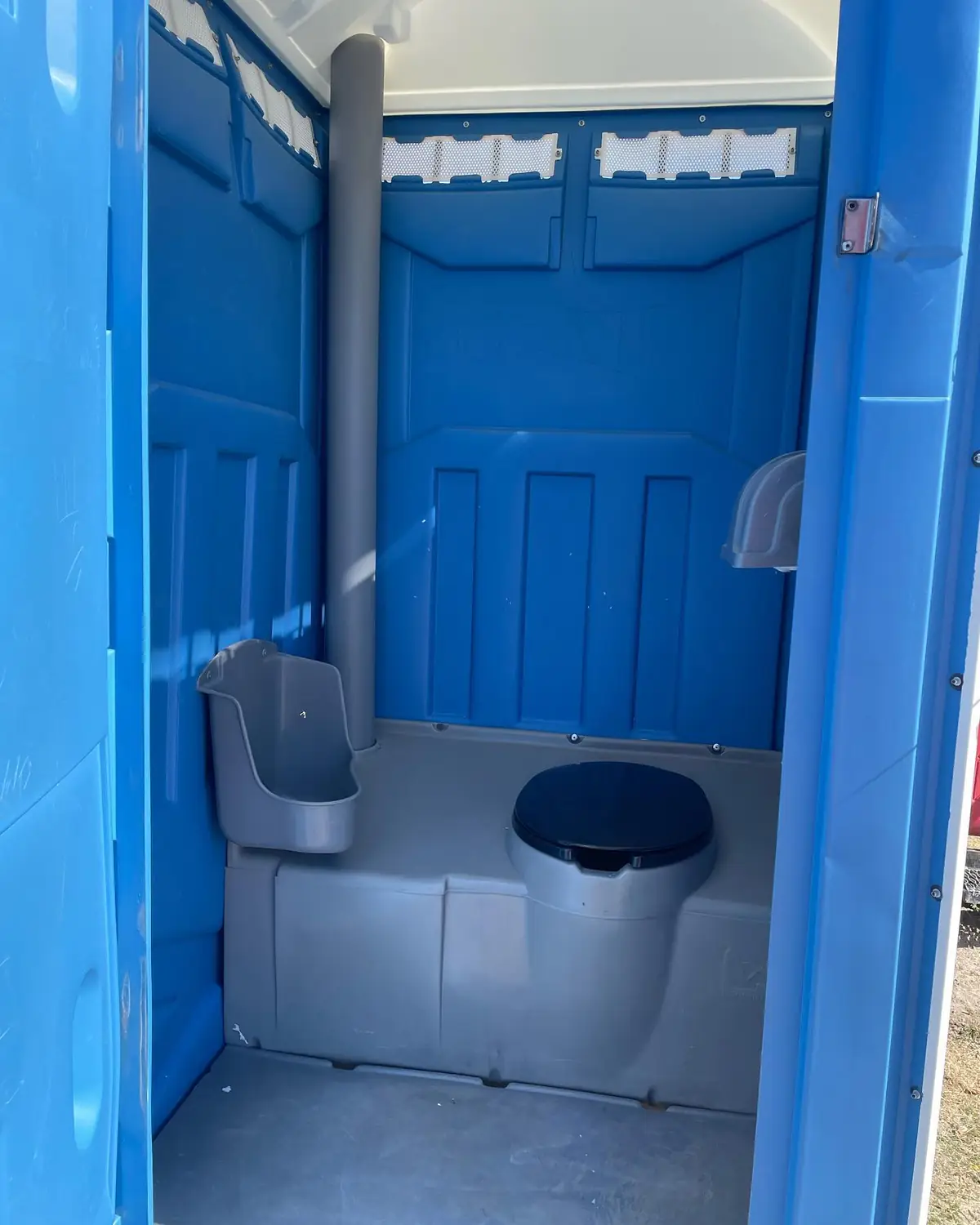 Standard unit interior after a service visit: urinal, seat, toilet paper and sanitizer restocked